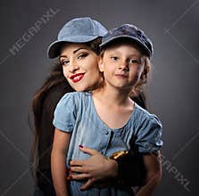 Happy smiling mother and daughter posing in blue baseball caps o