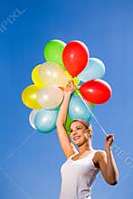 Woman holding bunch of balloons