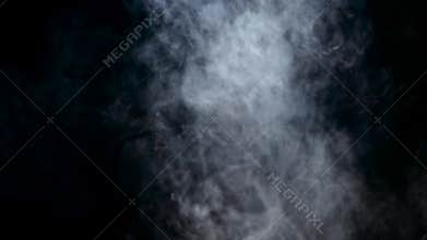 Smoke from an electronic cigarette is spreading in an empty room. Black background