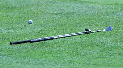 Golf club on green with ball