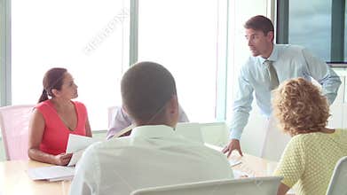CEO Addressing Meeting Of Businesspeople In Boardroom