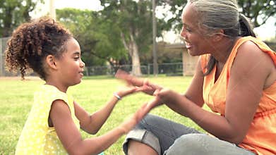 Grandmother And Granddaughter Playing In Park Together