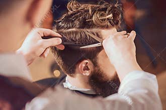 Professional barber styling hair of his client