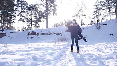 Young and beautiful couple in love walking in the winter woods