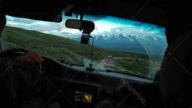Young man drives a car in mountains. Travel and adventure concept. Toned picture