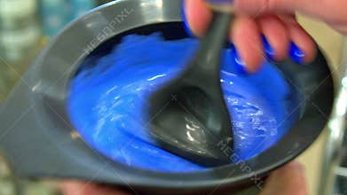 A hairdresser mixing a hair dye