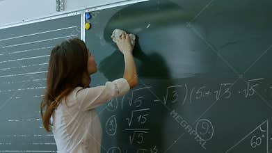 Young teacher erasing chalkboard.