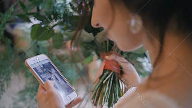 Young bride on wedding day using mobile phone