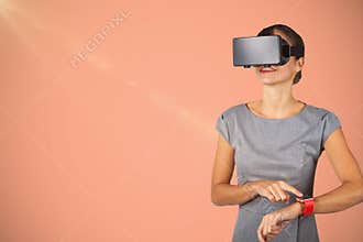 Composite image of smiling young woman standing while using virtual video glasses