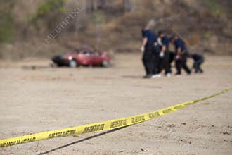 police line do no cross with blurred car and group of law enforcement background