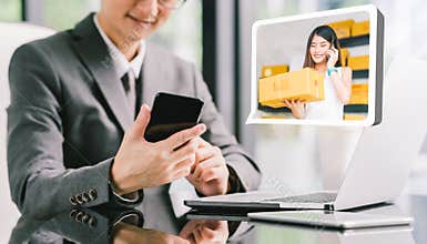 Businessman CEO order product box from young female Asian small business owner using phone, laptop. E-commerce technology concept