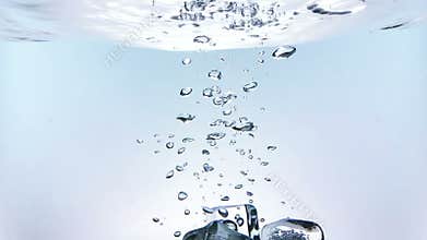 Ice cubes falling down splash into water on white background, shot slow motion, fresh drink summer time