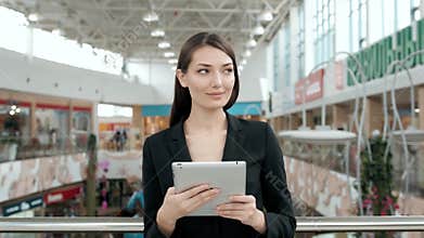 Young female passenger traveller at the airport using her tablet computer while waiting for flight, business woman after