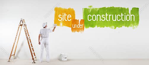 Painter man with paint brush drawing under construction text