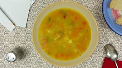 Rotating bowl of vegetable soup on the dinner table