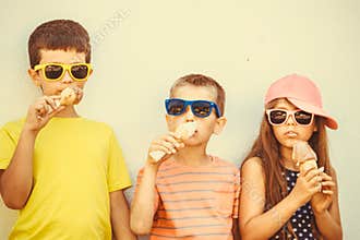 Kids boys and little girl eating ice cream.