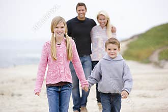 Family walking at beach holding hands