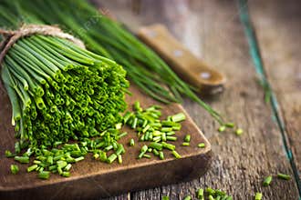 Bunch of fresh chives on a wooden cutting board