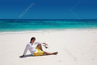 Summer. Relax. Successful handsome man resting on exotic beach w