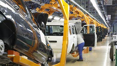 Female worker assembly cars on conveyer