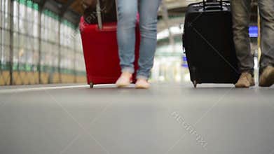Feet walking on the platform passengers with a suitcase, young couple walking along the platform to the train with