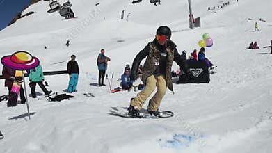 Snowboarder slide on iron trail, but fail. Ski resort. Sunny day. Extreme sport