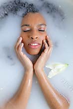 Close up portrait of beautiful black girl taking milk bath.