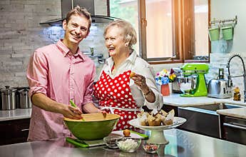 Grandmother baking cupcakes with her grandson