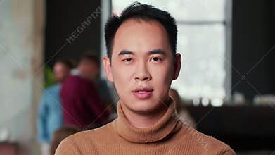 Portrait of young confident happy Asian business mentor coach looking at camera at modern trendy office workplace.