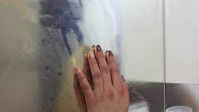 Hand on misted frosted glass, danger and horror of the paranormal