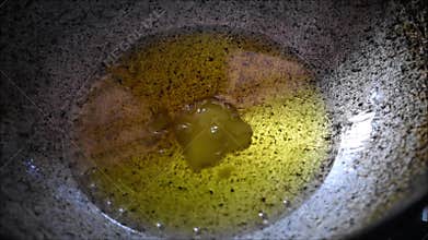 Video of ghee or clarified butter melting to liquid form on a hot pan
