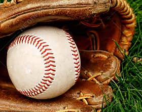 Baseball with mitt in grass