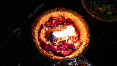 A Single Beautiful candle and flower offerings floating on the river - Varanasi, India