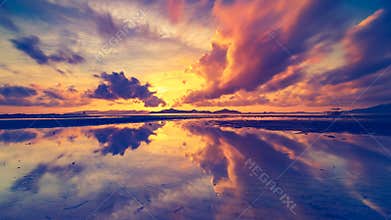 Orange pink and purple evening clouds reflected in sea