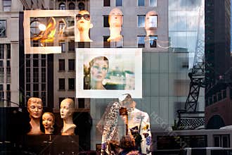 Window shopping New York - reflections from high rise buildings and advertising with Tour Eiffel in window pane. Inside, outside.