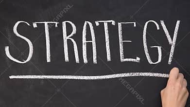 Hand underlining word strategy on blackboard, business motivation, start-up