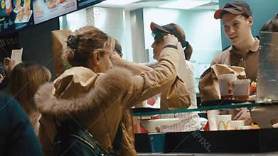 Moscow, Russia - December 15, 2019: A friendly and smiling male and female managers in McDonald`s verified with payment