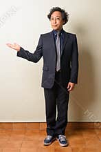 Full body shot of Japanese businessman in suit showing something