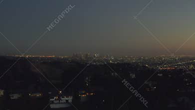AERIAL: Over Hollywood Hills at Night with view on Downtown Los Angeles view,