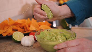 Making guacamole - closeup on hands squeezing lime