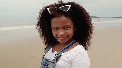 Video portraits, An African-American girl who smiles and scowl faces on the beach.