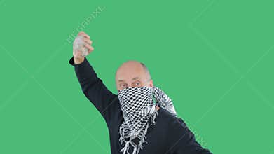 Anarchist in checkered bandana swings stone om green background on demonstration. Bald vandal with stone on civil
