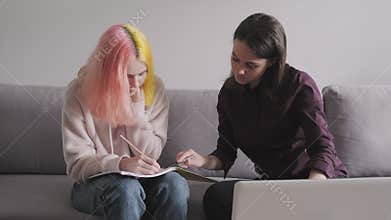Teen student girl 15, 16 years old has individual lesson from young woman teacher
