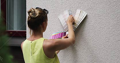 Woman choosing paint color for house exterior stucco facade