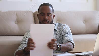 Focused african man student freelancer typing on laptop doing paperwork