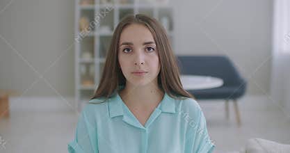 The woman listens while looking at the camera and nods her head approvingly. Participant in the video call dialog. Video