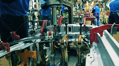 Factory facility interior, industrial equipment. Car manufacturing worker welding a car part. Close up