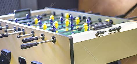 Children`s game - table football with figures of football players of both teams in a wooden box in the playroom for teenagers.