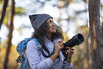 African American woman in the forest with a camera.