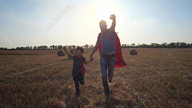Father and son as superheroes running across field